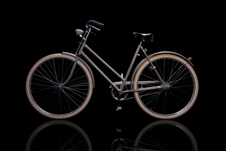 Old refurbished retro bike isolated on black background with reflection side viewの写真素材