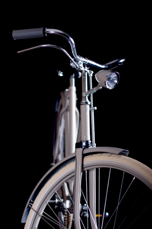 Old refurbished retro bike isolated on black background detail view of the lever brake, handlebars and headlightの写真素材