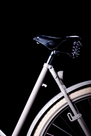Old refurbished retro bike isolated on black background detail view of black leather saddleの写真素材