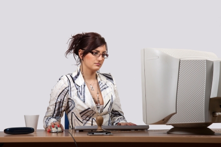 Young female office worker is concerned to work on computerの写真素材