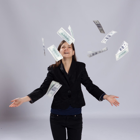 Young long-haired woman throws dollars up toの写真素材