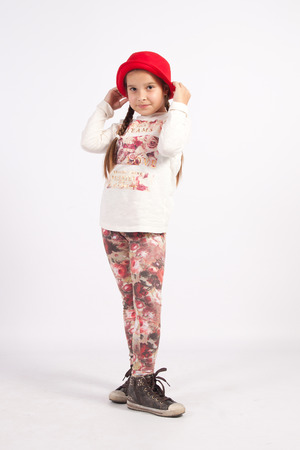 The little girl's hat, red, staring in front of himselfの写真素材