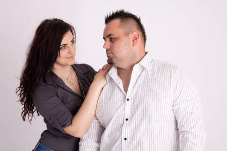 Portrait of long-haired woman rests on the shoulders of a man in a white shirt, looking at each otherの写真素材