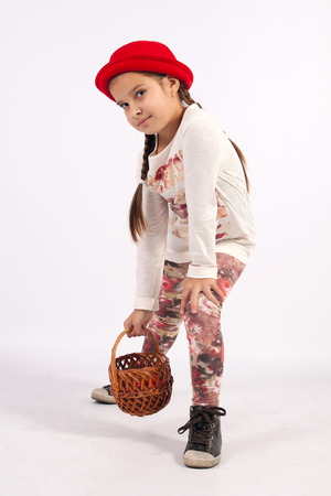 The little girl in a red hat, holding a hand basketの写真素材