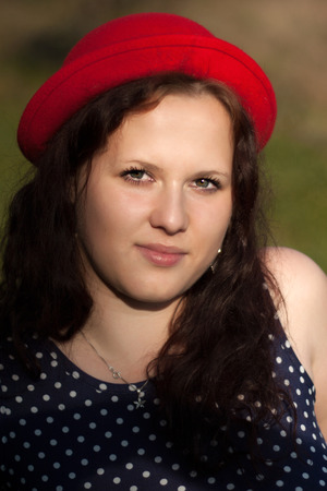 Young woman in red hat looks at the sunの写真素材