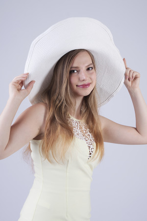 smiling young lady in white hatの写真素材