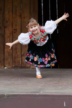 Smiling, happy little girl in traditional costumeの写真素材