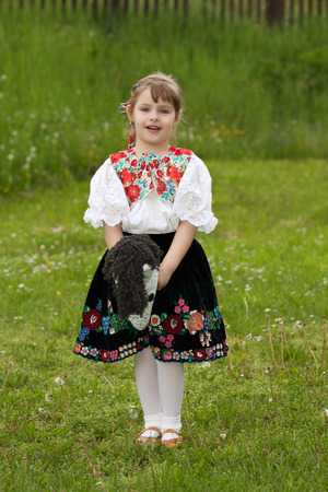 Little girl playing with tailstock on a meadowの写真素材
