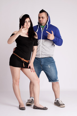 Young couple in rapper clothes posing in the studioの写真素材