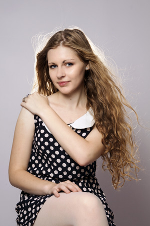 Young long-haired curly blonde woman presented beautiful natural long curly blond hairの写真素材
