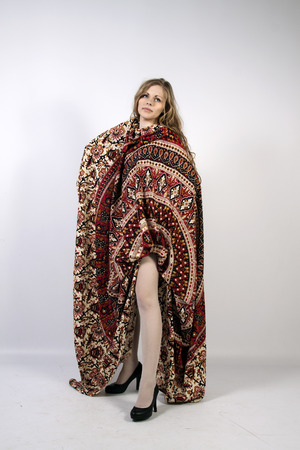 Young long-haired curly blonde woman posing wrapped in a mandalaの写真素材