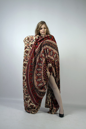 Young long-haired curly blonde woman posing wrapped in a mandalaの写真素材