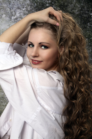 Young long-haired curly blonde woman presented beautiful natural long curly blond hairの写真素材