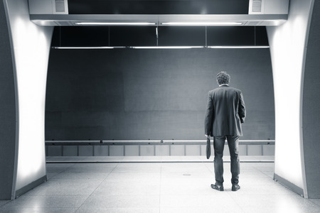 A young businessman with phone in the subway, blurredの写真素材