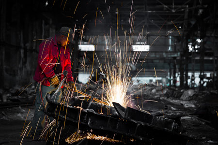 worker in factory cutting steel pipe using metal