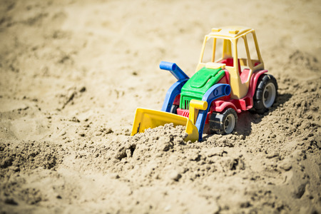 a colorful plastic toy excavator in the sandboxの写真素材