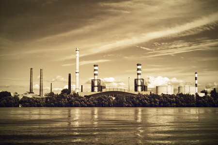 an industrial facility next to a river, sunsetの写真素材