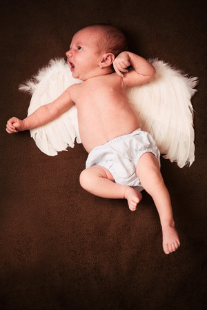 a newborn baby lying on brown blanketの写真素材