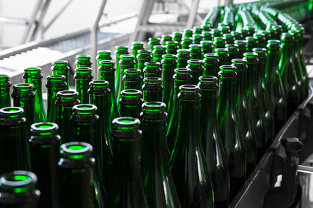 empty liquor bottles on the conveyor beltの写真素材