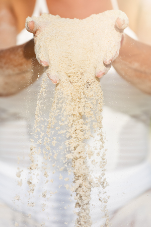 a female hand releasing dropping sandの写真素材