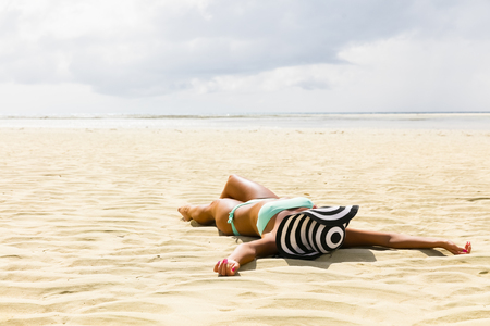 young woman lying on the sandの写真素材