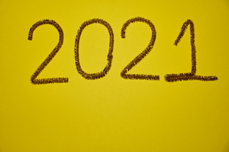New year 2021 inscription made of glittering tinsel with a yellow background.の写真素材