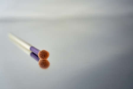 makeup brush with mirror reflection on blurred backgroundの写真素材