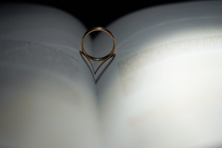 Shadow from the ring on the book in the form of a heart blurred. Copy space