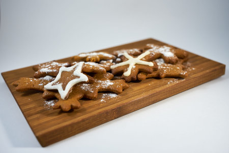 Ginger biscuits close up with sugar powder on a wooden board.