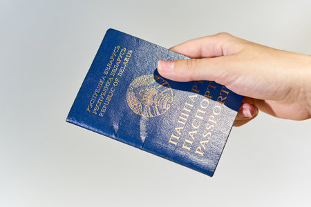 Woman's hand giving passport of Belarus close up.の写真素材