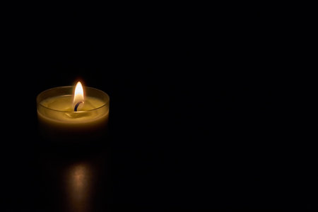 A candle in darkness. Copy space.の写真素材