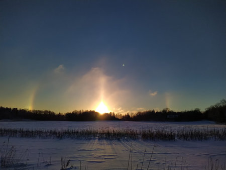 Halo effect on a frosty evening with a snowy field in the foreground.の写真素材