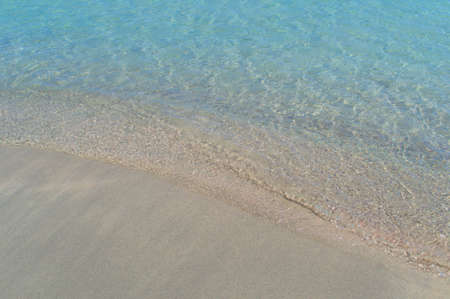 A small wave of the sea covers the sand on the paradise beach.の写真素材
