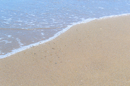 Texture of sand with an edge of sea-wave foam.の写真素材