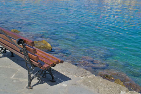 Wooden bench on the promenade by the sea.の写真素材