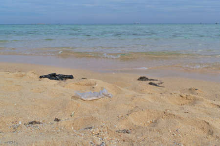 Plastic garbage bags on the sandy seashoreの写真素材