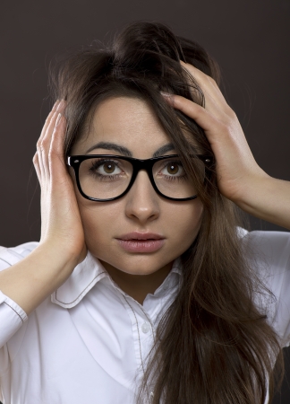 Surprised woman with black glasses and white shirtの写真素材