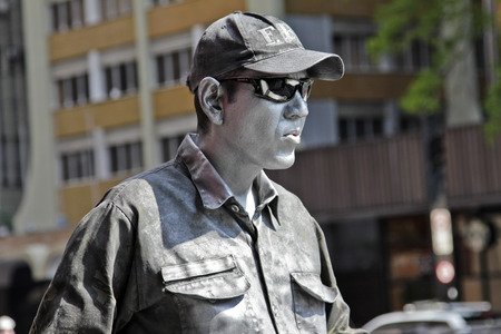 SAO PAULO, BRAZIL - FEBRUARY 08, 2015: An unidentified street artist imitates a police dressed with typical cop dress in Paulista Avenue at Sao Paulo Brazil.のeditorial素材