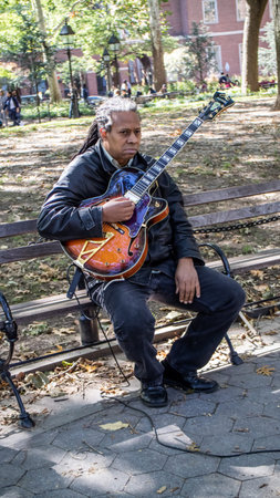 NEW YORK, USA, October 10, 2015: An unidentified lonely guitar player perform his songs in Washington Square Garden in Manhattan, New York.のeditorial素材