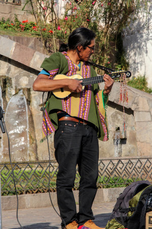 Man in typical peruvian clothes playing on the street for tourists in Cuzco Peru