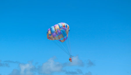 Punta Cana, Dominican Republic - October 24, 2018: Unidentified people flying with paragliding on the beach of Bavaro at Punta Cana region in a sunny day.のeditorial素材