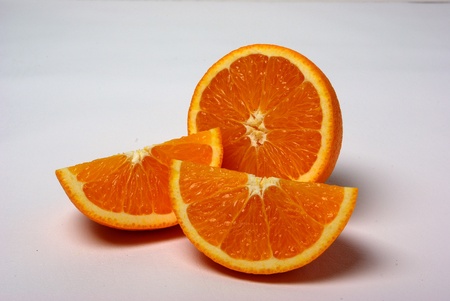 A whole and sliced orange sits on a white background.の写真素材