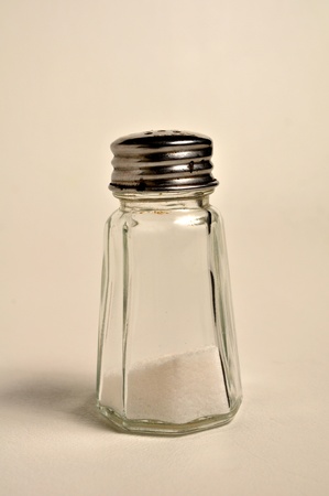 A salt shaker is standing upright on a white background.の写真素材