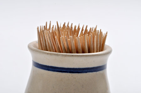 Toothpicks in a toothpick holder on a plain background.の写真素材