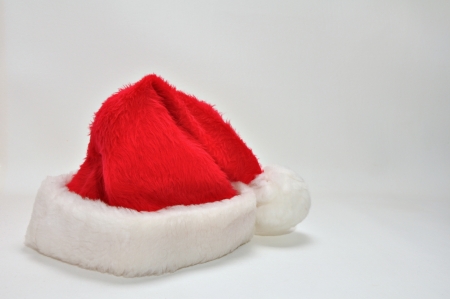 A red and white Santa Claus hat is resting on a white background の写真素材