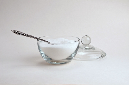 a spoon is resting in a uncovered surgar bowl.の写真素材