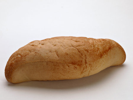 A single white Bolillio roll is sitting on a white backgroundl