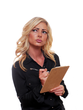 Attractive blond business woman is writing on a clipboard.の写真素材