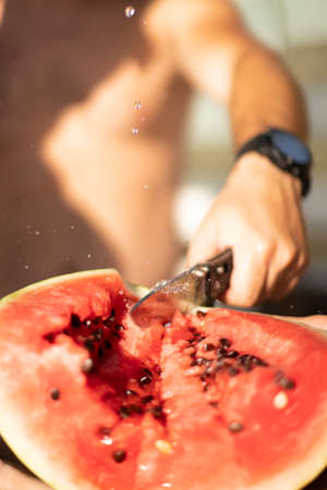 The knife cuts a juicy watermelon and splashes flyの写真素材