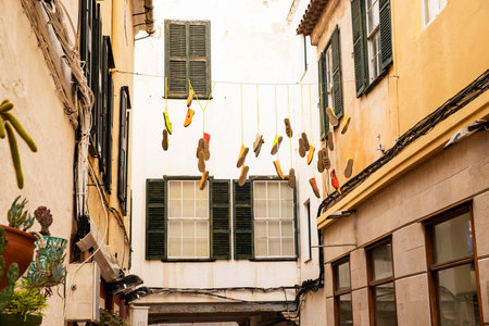 Traditional architecture with unusual street decor made of shoes Menorca Spain